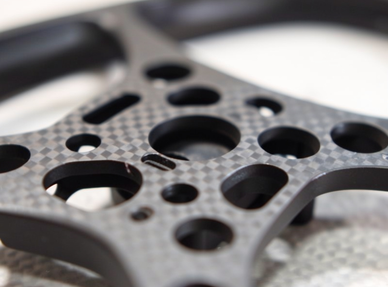 Close-up of a cinewhoop carbon center plate with ducts and an action camera mount