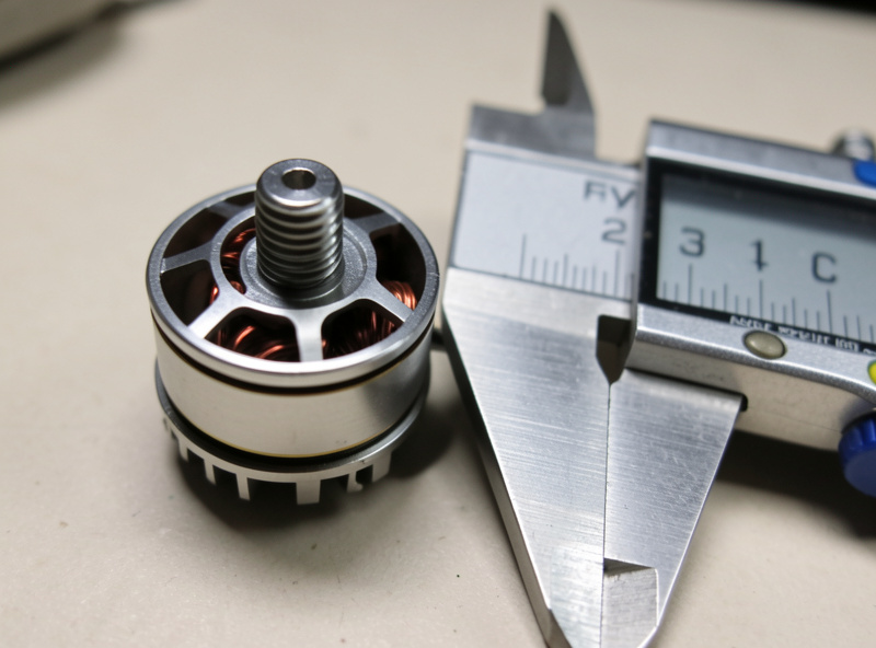 Close-up of an FPV motor specification chart and a digital caliper measuring stator height