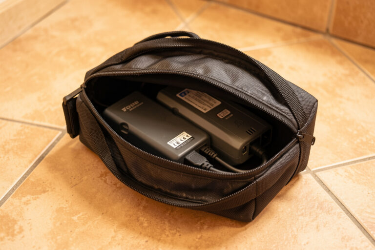 A LiPo battery charging inside a closed fireproof safe bag on a non-flammable bench surface