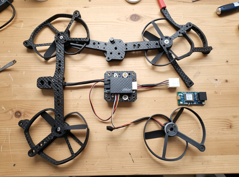 Parts laid out for a 7-inch long-range FPV build: frame, motors, FC stack, GPS module and 900MHz receiver