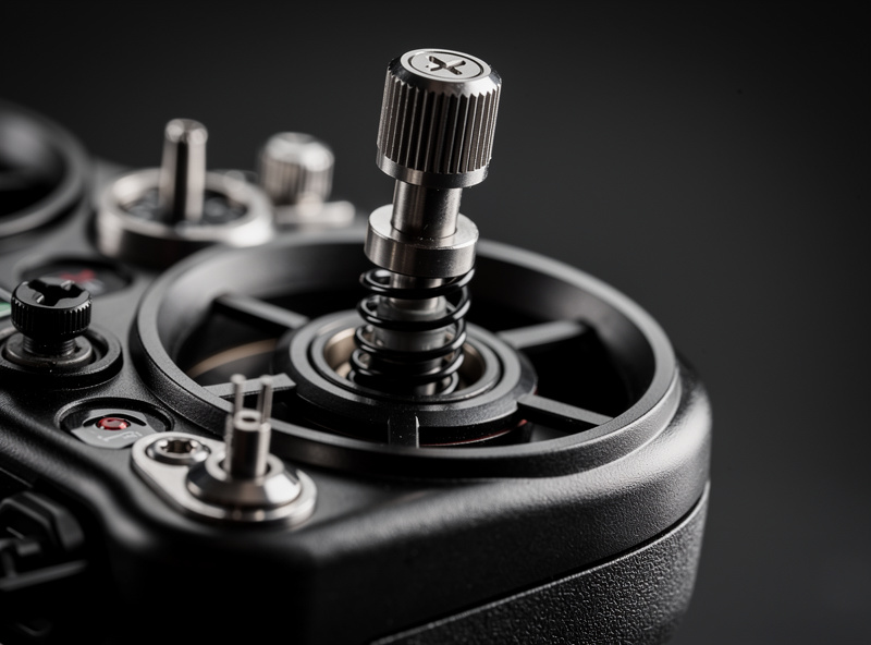 Close-up of an FPV radio transmitter's hall-sensor gimbal stick, showing the precise control mechanism